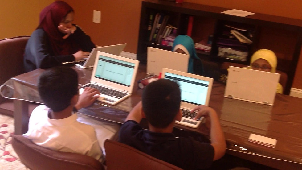 Students learning on laptops with their teacher in an AlminarAcademy classroom